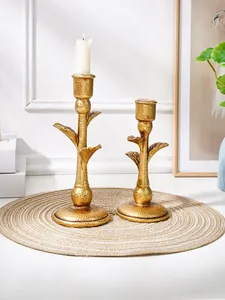 Luxury vintage gold coconut tree candle holders set on woven mat for wedding table decor