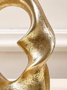 Detailed macro view of golden textured resin spiral sculpture with elegant metallic finish