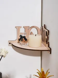 Decorative wooden corner shelf with HOME letter cutout design holding a candle and perfume