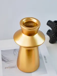 Close-up detail of a Nordic lighthouse-style resin decorative vase with matte gold finish