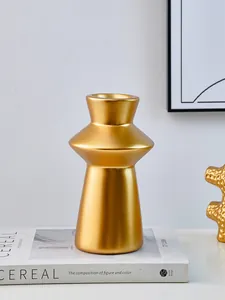 Modern gold lighthouse decorative resin vase placed on a stylish book for home decor