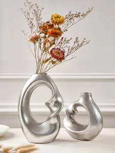Modern silver spiral resin vases featuring artistic abstract shapes and grainy texture.