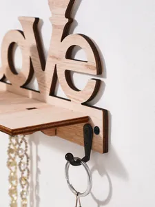 Close-up of the wooden LOVE wall hook showing the black metal hook and wood grain detail