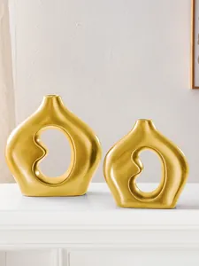 Detail der modernen mattgoldenen bohnenförmigen Keramikvasen für die Wohneinrichtung