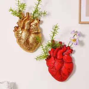 Jarrones de pared creativos con forma de corazón anatómico en colores oro y rojo.