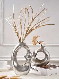 Abstract silver spiral resin vases set with dried plant decorations for home decor.