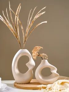 Modern abstract spiral resin vase with beige matte finish and dried flowers