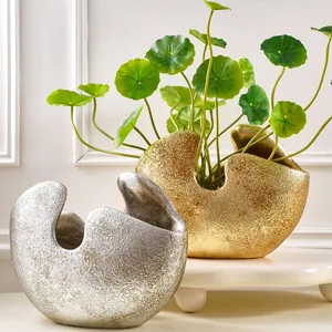 Moderne halfronde harsvazen in goud en zilver voor een stijlvol en elegant interieur.