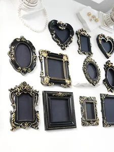Artistic display of vintage baroque style mini black and gold picture frames on wall