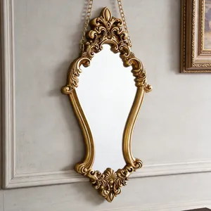 Close-up detail of an ornate golden vintage wall mirror featuring Baroque carvings