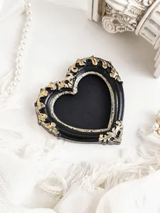 Macro view of a heart-shaped vintage black and gold ornate magnetic photo frame
