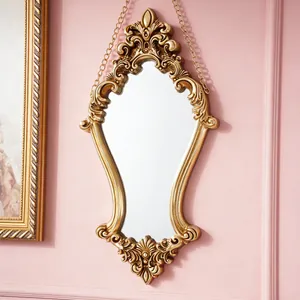 Detailed view of the elegant gold relief carving on a vintage European wall mirror