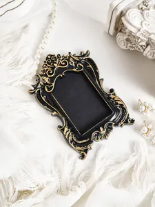 Close-up of vintage black and gold European mini photo frame with ornate carvings