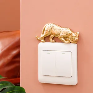Golden resin leopard figurine used as a decorative accent on a light switch panel