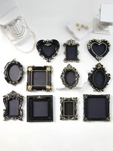 Collection of ornate mini black and gold vintage picture frames in various shapes