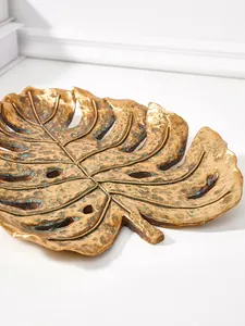 Gros plan d'une feuille de monstera dorée antique en résine pour décoration murale chic