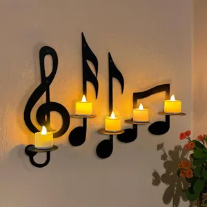 Detailed close-up of black iron music note wall candle holders with warm glowing lights