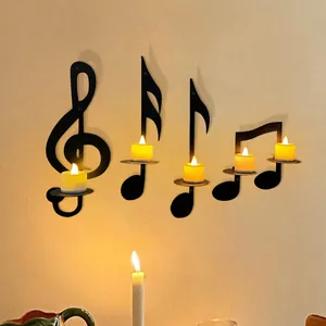 Black wrought iron musical note candle holders mounted on a warm toned wall