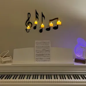 Close-up of black musical note wall candle holders mounted above a white piano