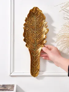 Vue détaillée d'un décor mural en feuille de résine dorée montrant texture et taille
