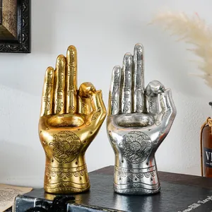 Detailed macro view of vintage gold and silver resin palm candle holders with sun patterns