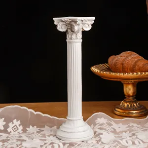 Candelabro de columna romana de resina blanca envejecida en un ambiente de mesa vintage