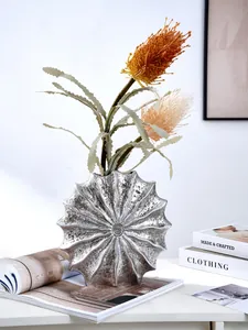Modern silver resin vase with a unique radial sea shell texture and artificial flowers
