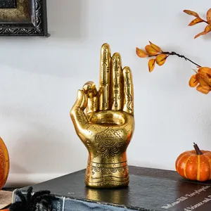 Detailed macro view of retro golden palmistry resin hand candle holder with mystical engravings