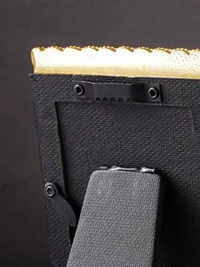 Detailansicht der Rückseite eines goldenen Vintage-Rahmens mit Aufhänger und Ständer