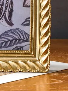 Detailansicht eines goldenen Retro-Bilderrahmens mit spiralförmiger Textur