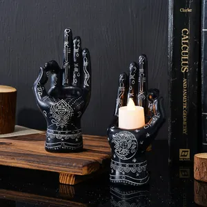 Detailed view of mystical palmistry engravings on black resin hand candle holder