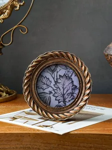 Antiker goldener runder Bilderrahmen mit Spiralmuster für elegante Wohndekoration und Tische.