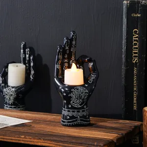 Mystical black resin palm candle holder with celestial sun and moon motifs for Halloween