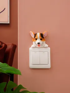 Close-up view of a cute Corgi resin decorative sticker placed on a white light switch
