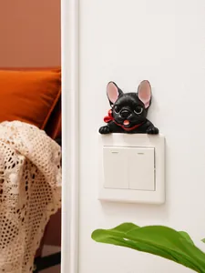 Detail showing a 3D resin French Bulldog figure sitting on top of a white light switch