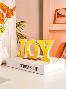 Detailed view of yellow mirror surface JOY alphabet ornament for home table decoration
