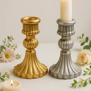 Detalle de candelabros vintage de resina tipo columna romana con acabado en oro y plata envejecido