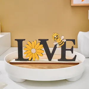Detailed view of a wooden LOVE ornament featuring a yellow daisy and a cute bee.