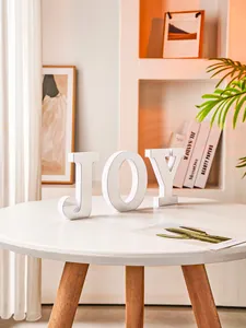 Detailed view of white mirror PVC JOY letter sign on table for modern home desk decoration