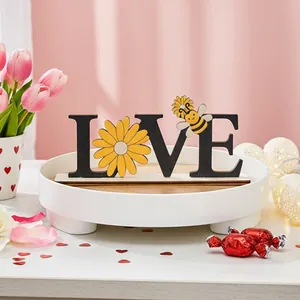 Macro view of wooden LOVE sign with decorative bee and flower details