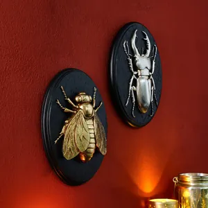 Close-up detail showing the vintage gold bee and silver beetle 3D resin wall relief plaques