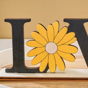 Detailed macro view of a wooden LOVE letter desk ornament featuring a yellow flower