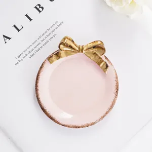 Elegante bandeja para joyas rosa con lazo dorado para el almacenamiento del tocador
