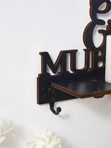 Détail d'un crochet mural en bois noir avec des lettres décoratives découpées au laser