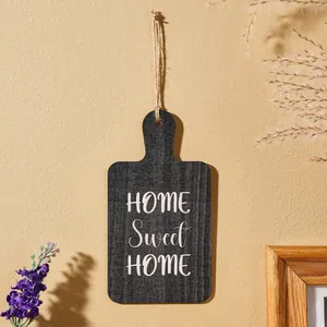Detail einer Holztafel in Anthrazit mit weißem HOME Sweet HOME Slogan und Hanfseil