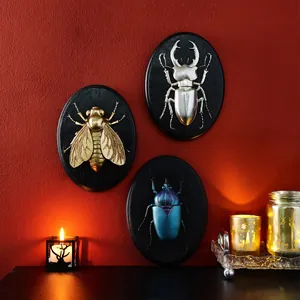 Three retro 3D resin insect wall reliefs featuring gold, silver, and blue beetles
