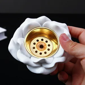 Primer plano detallado del quemador de incienso rosa blanca con inserto de metal oro