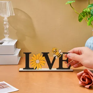 Close-up of wooden LOVE desktop ornament with sunflower and bee detailing
