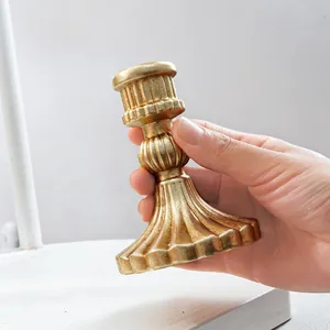 Primer plano de un candelabro vintage de resina dorada con forma de columna