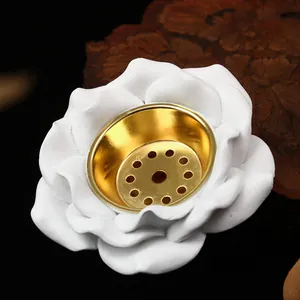 Detalle de un quemador de incienso de rosa blanca con un centro de metal dorado elegante